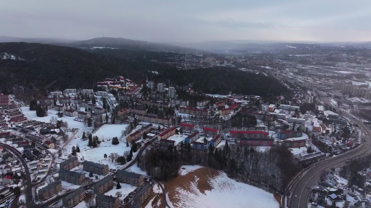 Tonsengagen Bjerke Arvoll Oslo Norge Norway aerial drone morning snowing snow flakes cold cloudy winter day gray skies city neighborhood apartment condominiums buildings cars traffic forward slowly