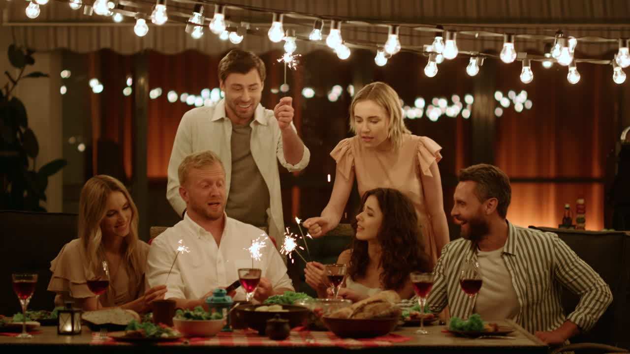 amigos sosteniendo bengalas en la fiesta de navidad. amigos usando un teléfono inteligente para selfie