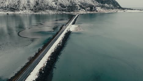 isolated road across the sea in lofoten island, northern norway. aerial drone shot