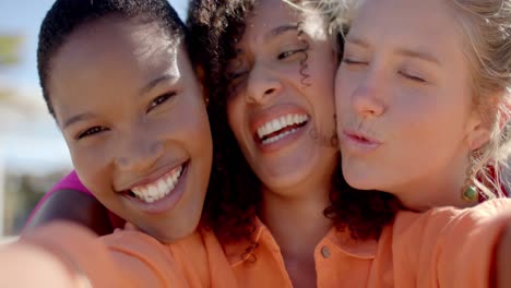 Portrait-of-happy-diverse-female-friends-embracing-on-beach