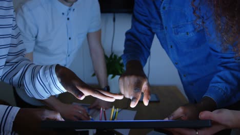 sección media de un joven equipo de negocios de raza mixta planeando y trabajando en una tableta digital en la oficina 4k