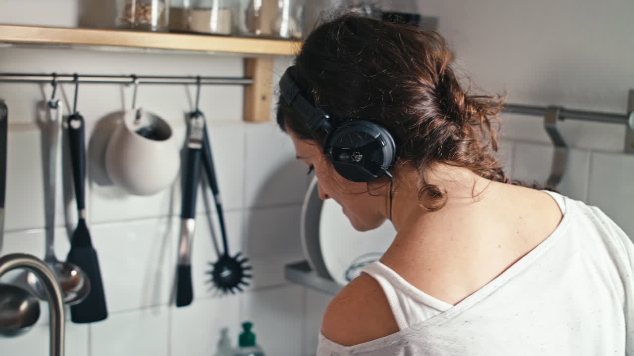 A woman in pajamas effortlessly preparing her healthy cereal while enjoying her favorite tunes on headphones. Perfect for busy mornings providing sustained energy and mental clarity throughout the day
