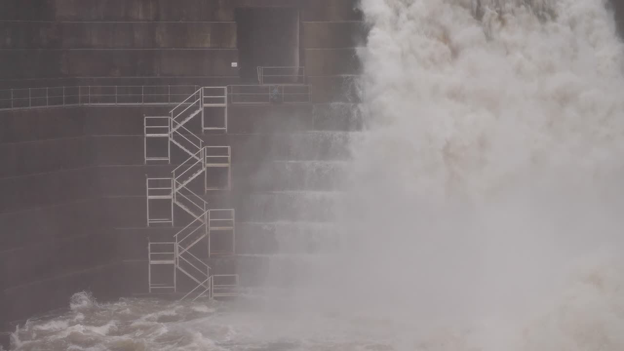 Close handheld shot of waterflow from Hinze Dam under heavy rain during La Ni&ntilde;a, Gold Coast Hinterland, Queensland, Australia