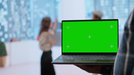 Realtors-and-client-evaluating-blueprints-next-to-green-screen-display