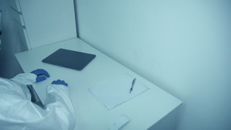 el personal médico con equipo de protección personal terminó de trabajar en su computadora portátil durante la pandemia de covid19
