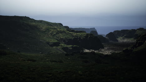 serene coastal landscape with rugged cliffs and green pastures during dusk