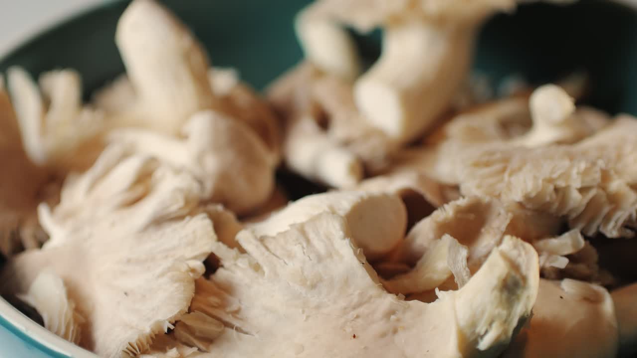 la mano de la mujer sostiene una canasta de setas de ostras pulmonares. un primer plano de la comida de los agricultores del supermercado.