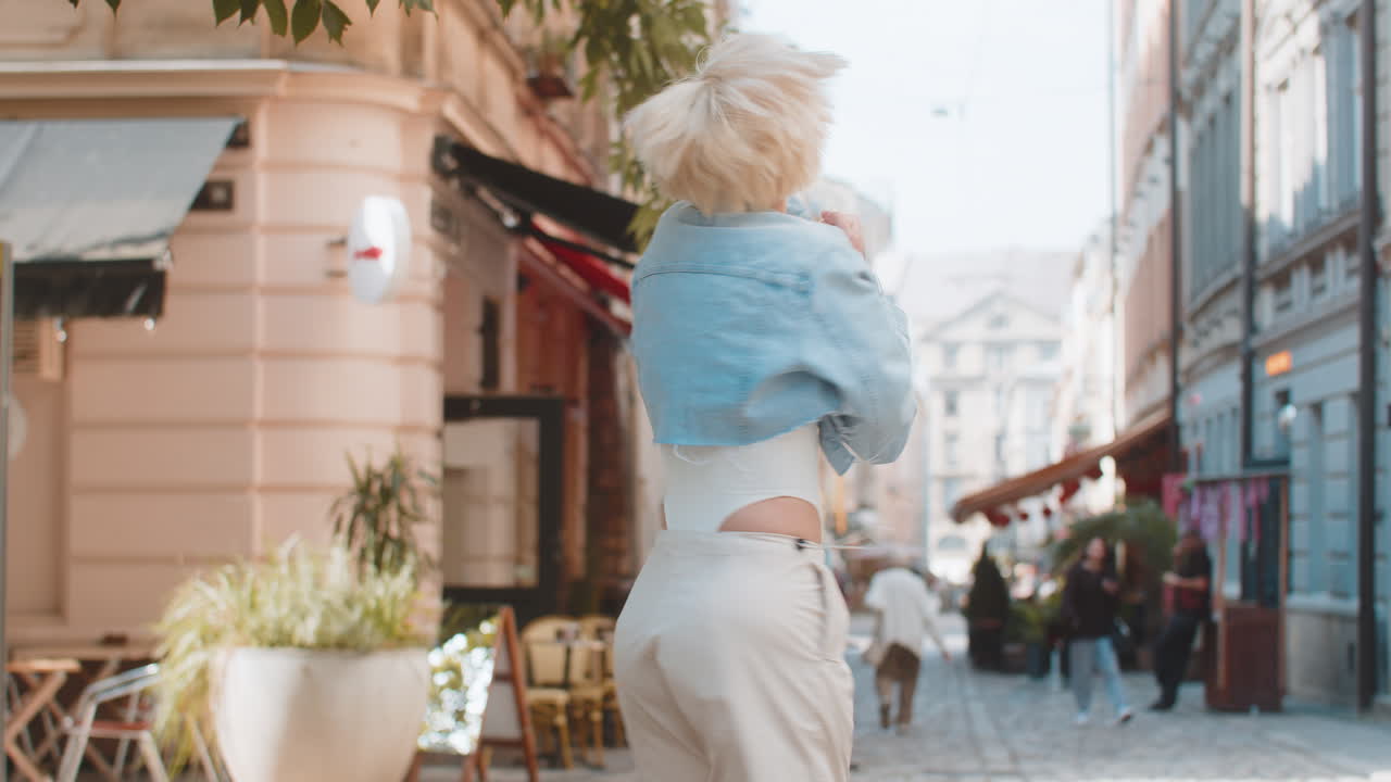 Excited surprised woman rejoices jumping with happiness feeling delight victory on city street