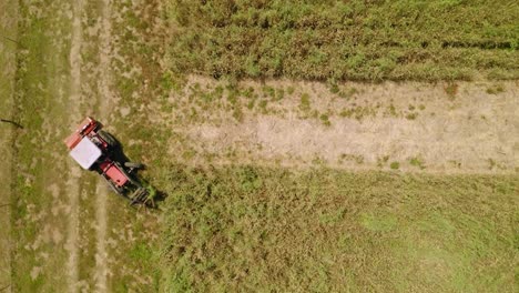 topdown of a tractor machinery mower moving on fields at sunny day