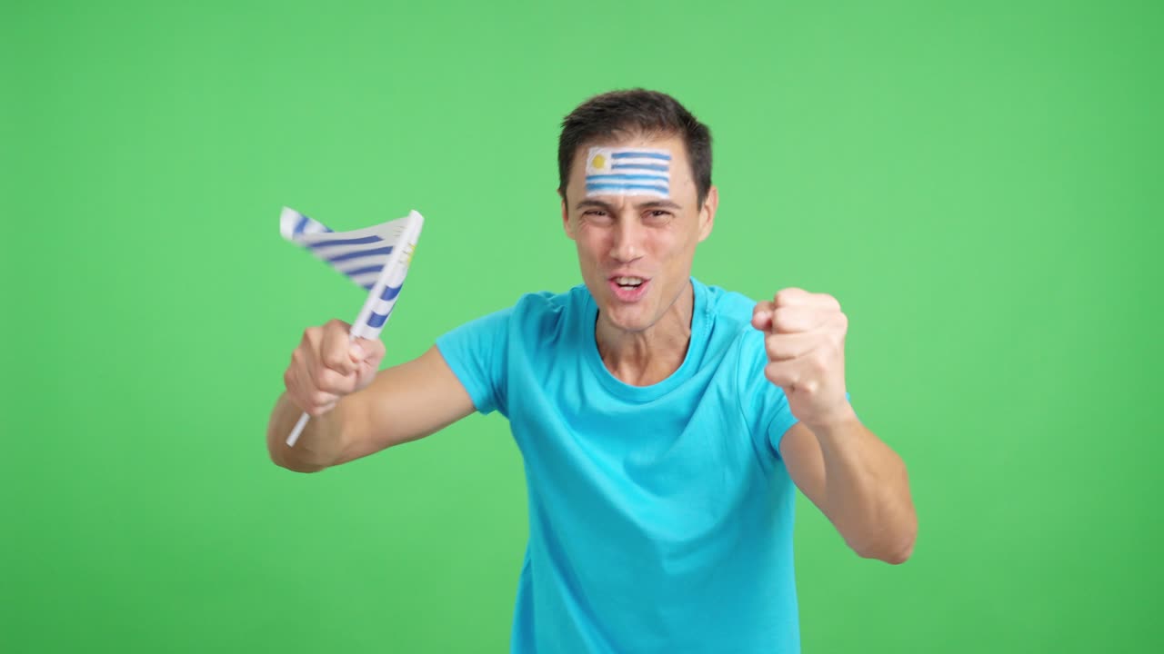 Man cheering for Uruguay screaming and waving a national flag