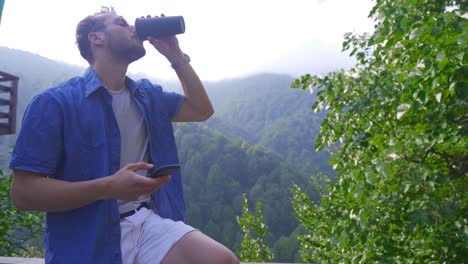 joven enviando mensajes de texto por teléfono móvil en un entorno natural.