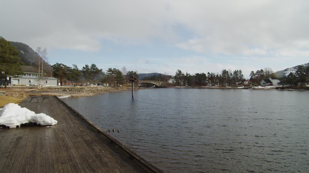 Vista panoramica del Lago Nisser, Treungen, Norvegia, suggestivo paesaggio invernale con molo in legno e natura nordica.
