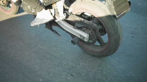 close-up shot of a person riding a power bike in motion, wearing a checkered shirt and sneakers, the bike's body and wheels are partially