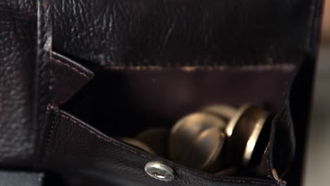 coins falling into leather wallet