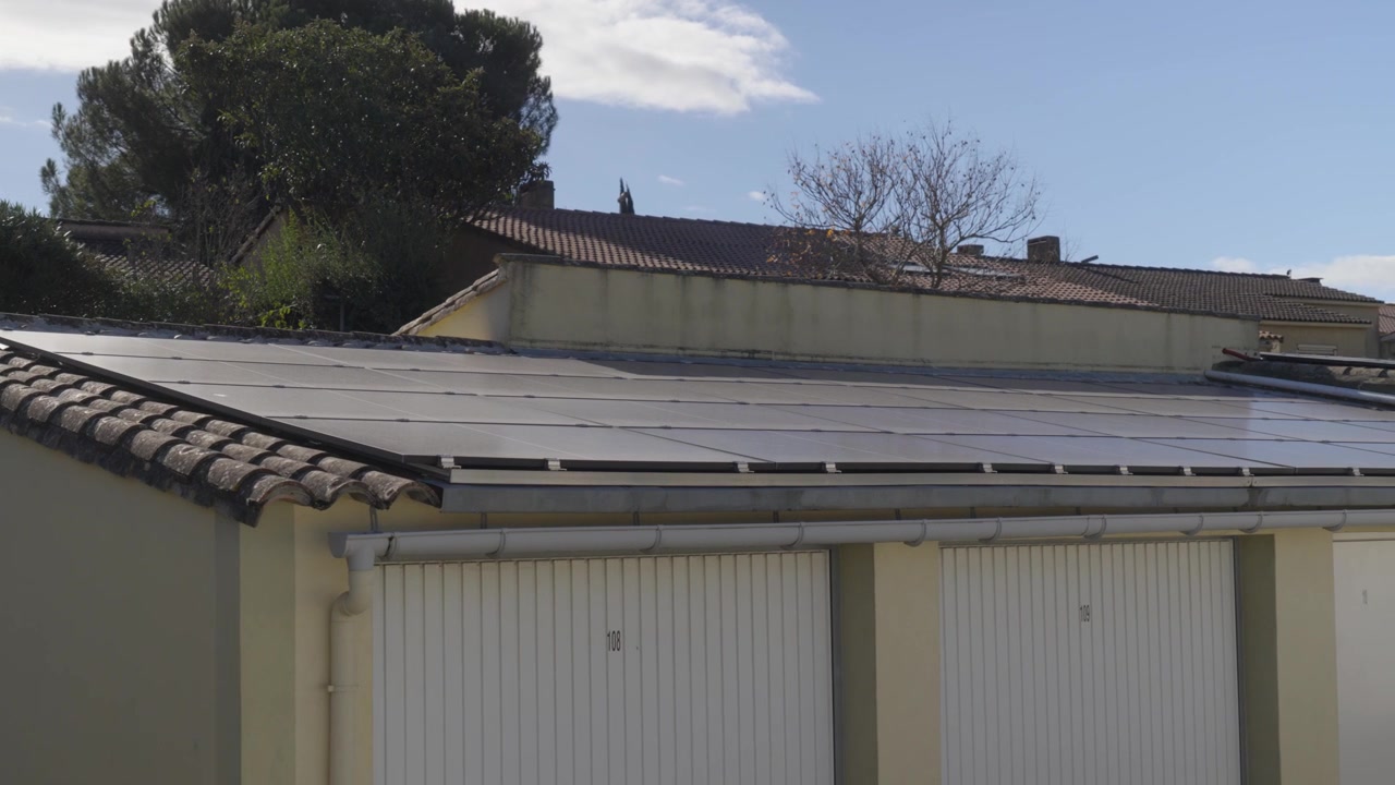 Rows of solar panels installed on the rooftop of garage units in sunlight