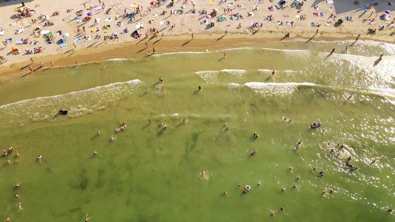 4k cinematic drone stock footage of people having fun at the beach on a sunny and hot day