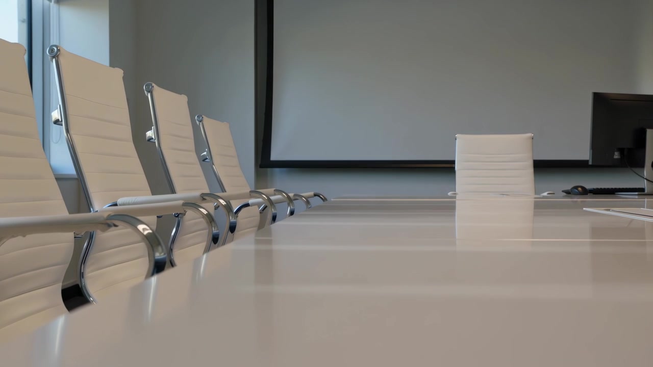 Gliding camera showing meeting setup with parallax on table and white chairs at office with monitor