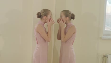 a group of young ballet students in black dancewear practicing positions in a spacious ballet studio with wooden flooring and wall-mounted barres. focused expressions and synchronized movements.