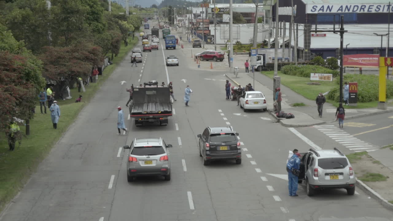 Dangerous highway crossing by a Venezuelan migrant camp in Bogota. Health officials and migrants risk their lives every second when they're at this camp with COVID-19 or cars and trucks on the highway