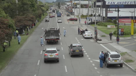 dangerous highway crossing by a venezuelan migrant camp in bogota. health officials and migrants risk their lives every second when they're at this camp with covid-19 or cars and trucks on the highway
