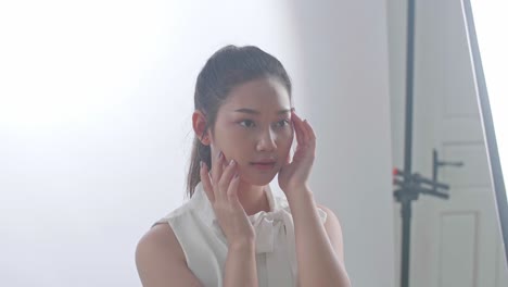 woman touching her face in a studio setting