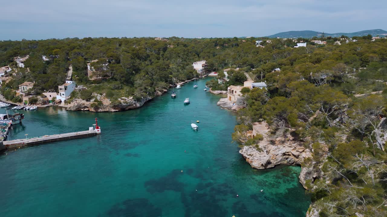 Marina con acqua di mare cristallina, blu turchese, navi a vela, barche e hotel, Isola di Palma di Maiorca