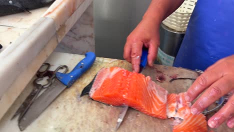 person filleting fresh salmon