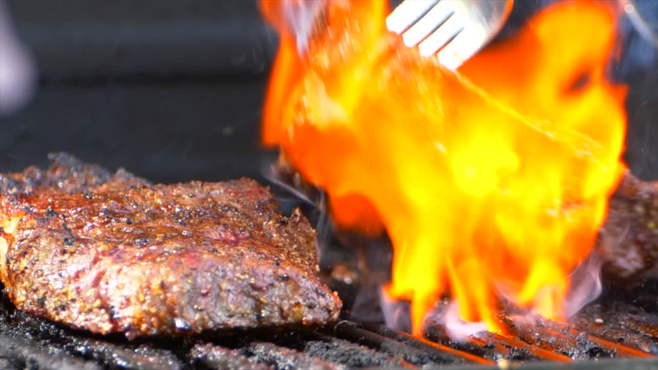 el mejor tiro de un tenedor convierte un jugoso filete de costilla casi cocido en una parrilla y llamas naranjas salen disparadas por debajo