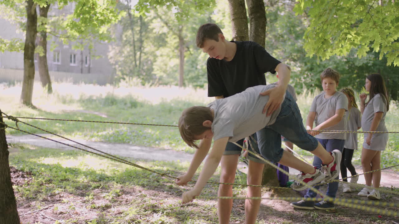 A boy learns to walk on cable cars and overcome cliffs and rope crossings in a summer camp
