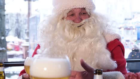 santa claus with a big white beard talking to friends in a cafe holding a glass of beer santa claus with a big white beard talking to friends in a cafe holding a glass of beer santa laughs happily christmas spirit of 2023