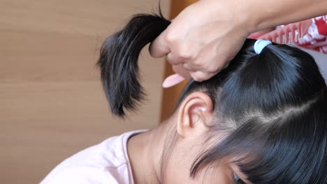 madre peinando el cabello de su hija