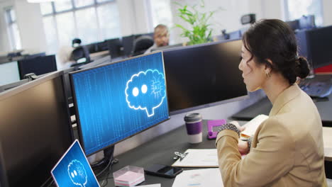 mujer de negocios biracial que usa computadoras con procesamiento de datos en la oficina