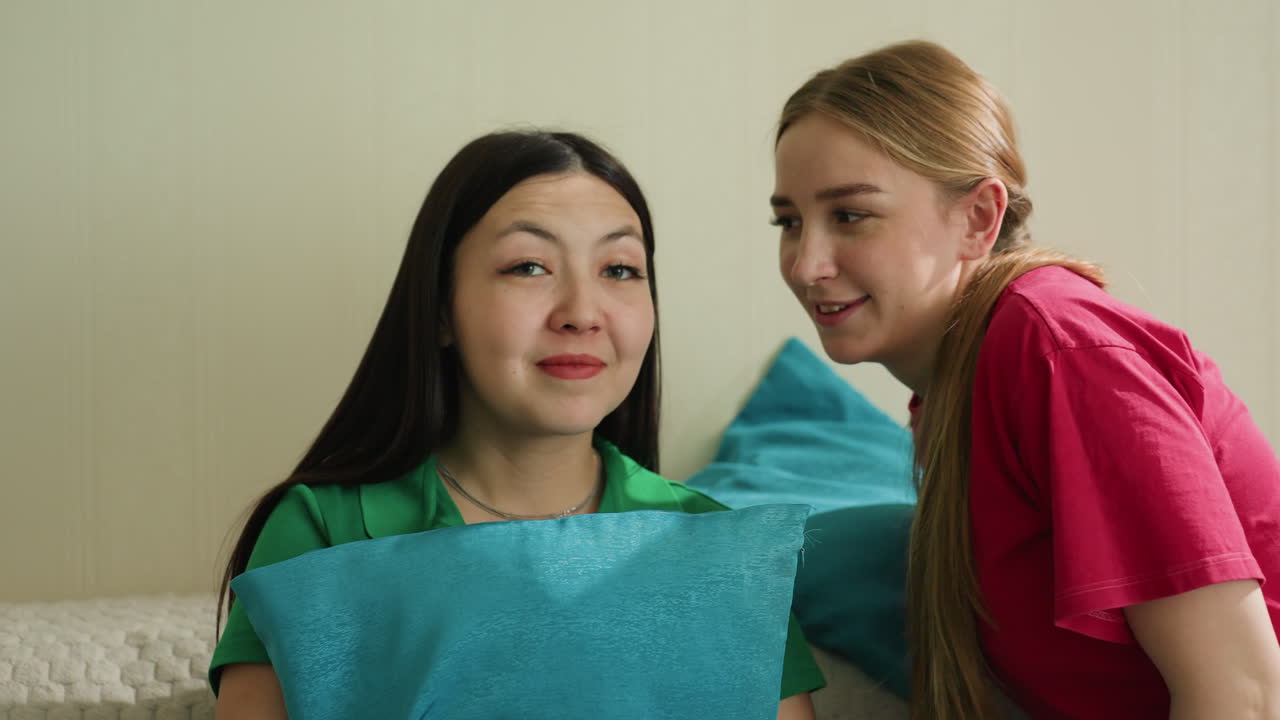 여성들이 편안하게 대화를 나누고 있어요. 두 여성이 진심으로 채팅하며 휴식을 취하고, 여성들이 함께 봉제 소파에 앉아 개인적인 이야기를 나누고 있어요. 두 여자는 삶과 우정에 대해 이야기하면서 소파에 부드럽게 앉아 있어요.