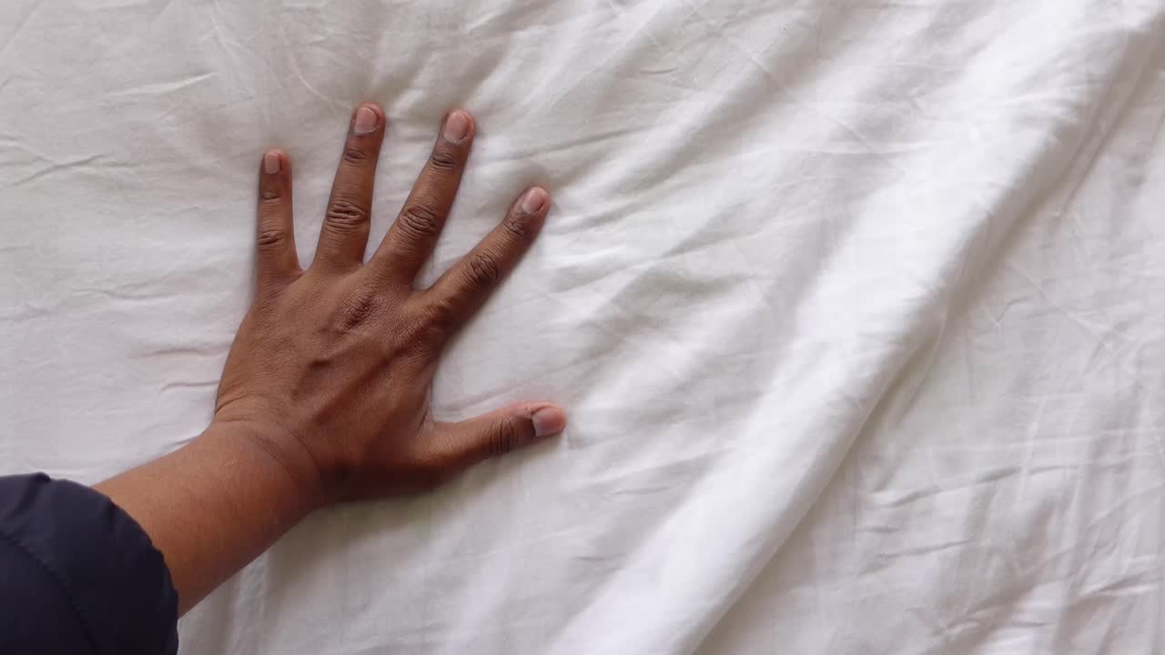 Hand on white bedding