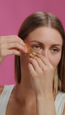 woman applying gold eye mask