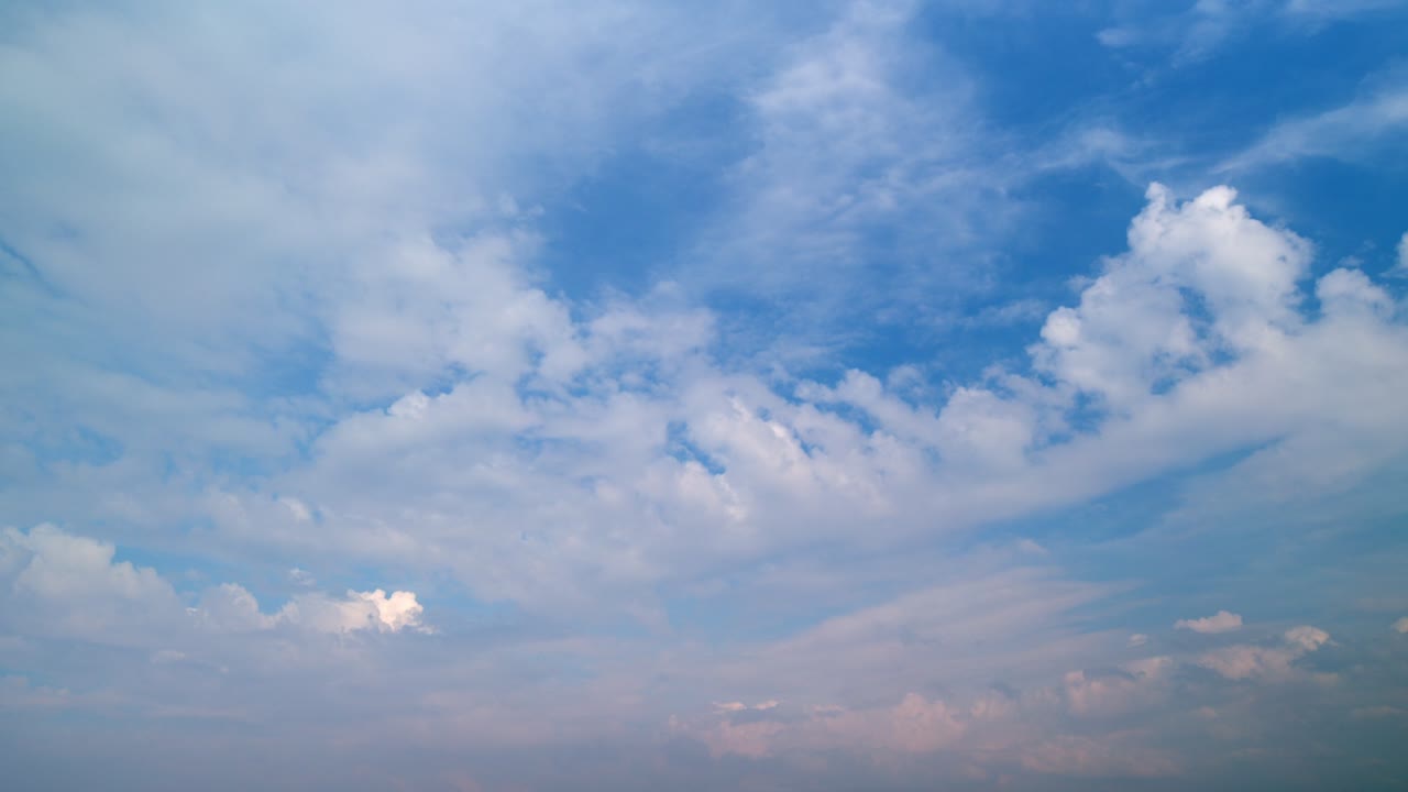 Fluffy curly rolling cloud in windy weather. Blue sky white clouds.