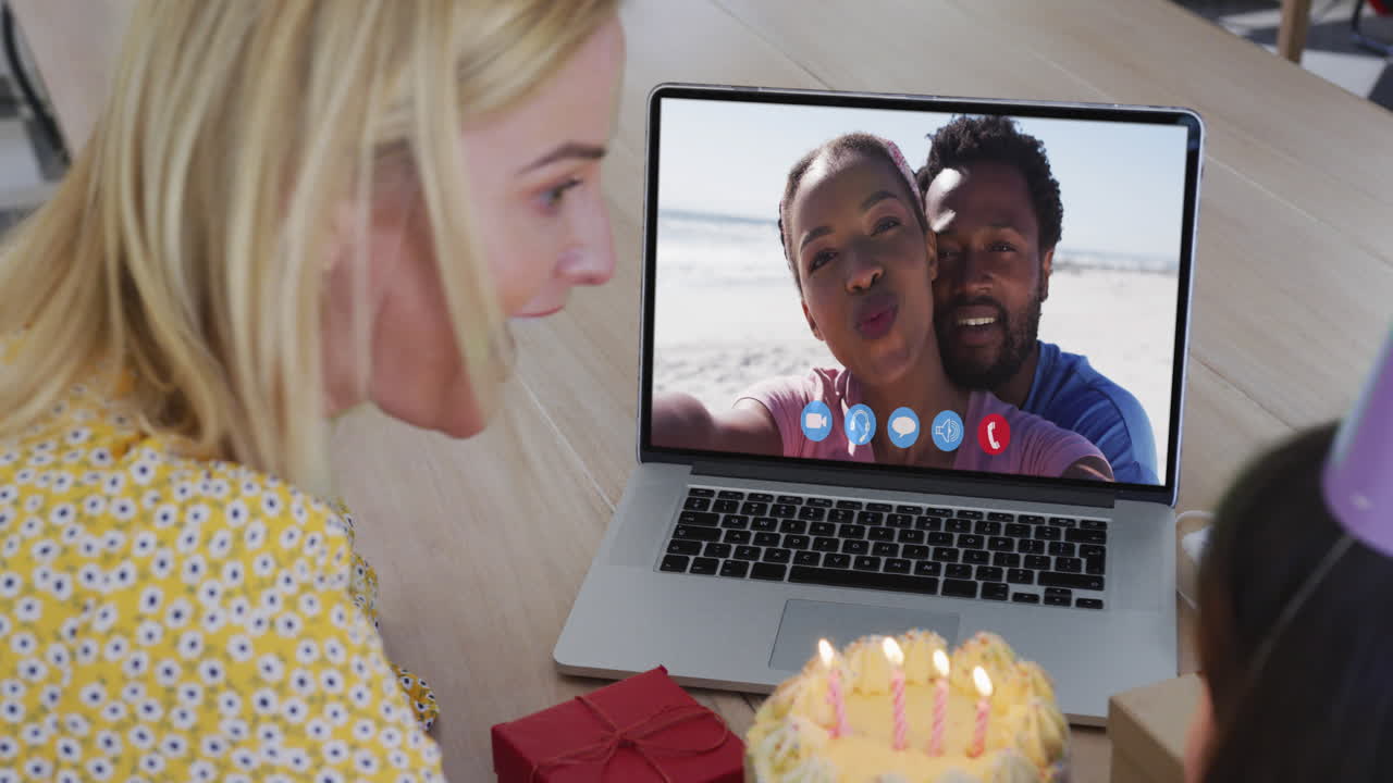 madre y hija caucásicas celebrando su cumpleaños en video llamada en computadora portátil en casa