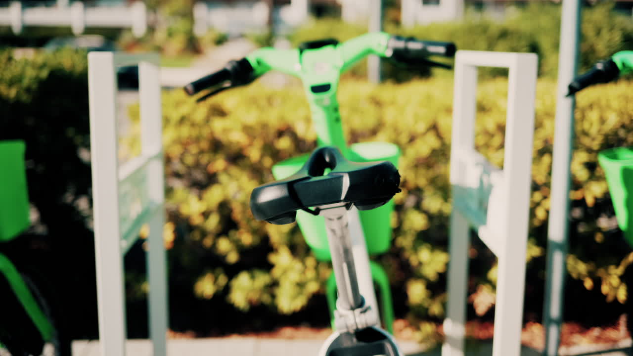 Close up of a green electric bicycle with modern design, parked outdoors under natural light