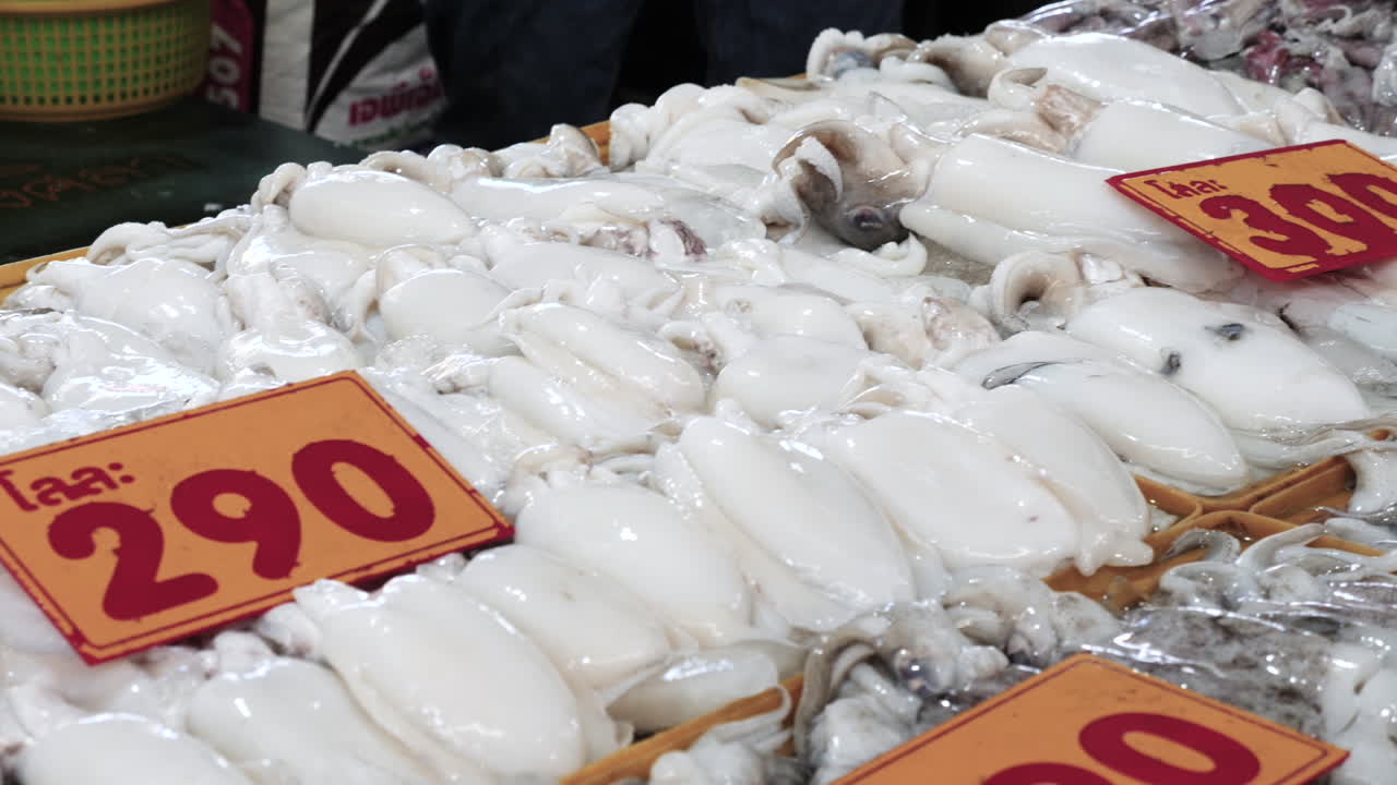해산물 시장 가판대에 있는 신선한 생오징어를 통한 모션 샷 - 길거리 음식 시장