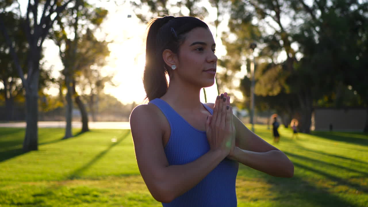 una bella y feliz joven hispana yogui sonriendo en una sesión de yoga de meditación en pose de oración al amanecer