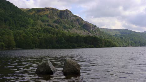 peaceful day in derwent water in the lake district national park with the centenary stones partly submerged in the ebbing lake