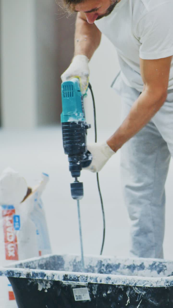 A focused worker operating a powerful drilling machine, demonstrating skill and concentration in a modern construction environment with a clean, white backdrop
