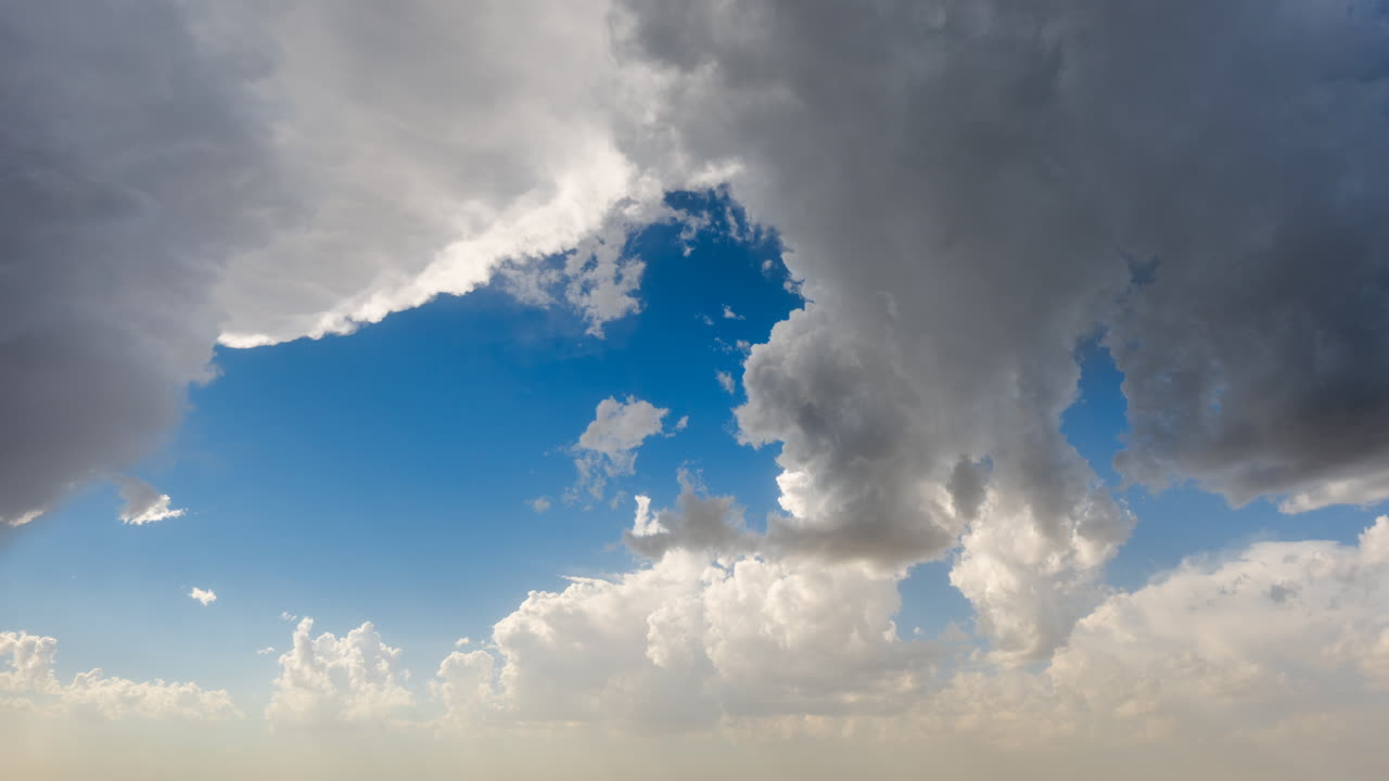 Rolling clouds crossing the sky with steady and building motion and contrast