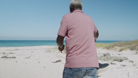 senior man with a bike at the beach