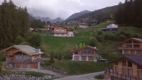 Imágenes-De-Drones-De-4k-Subiendo-Y-Bajando-Una-Montaña-Con-Cabañas-En-Los-Altos-Alpes-De-Suiza
