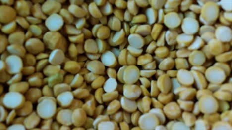 extreme close-up of bengal gram (chana dal) moving inside flour mill. ideal for food industry, agriculture, or documentary. 4k macro clip, great for culinary, health or educational content.
