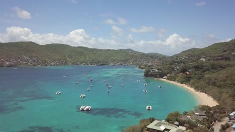 vuelo de drones sobre una laguna caribeña donde los barcos están atracados en las aguas azules azules poco profundas del océano caribeño