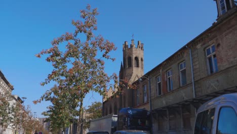 famous church cathedral in gdansk against blue sky on sunny day.truck passing road.bottom up.