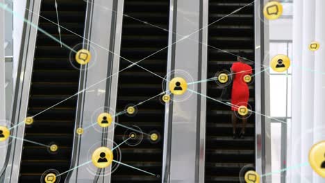 Animation-of-network-of-connection-with-icons-over-diverse-businesswoman-on-escalator-in-office