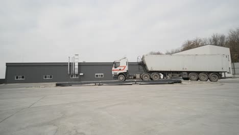 truck with raw materials is weighed on the scales in the grain storage area. truck scales